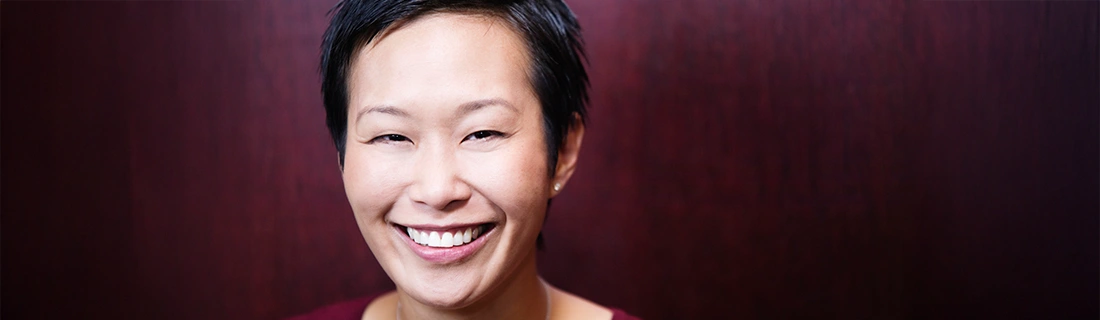 Dentist Merrimack NH Woman Smiling In Front Of Red Background